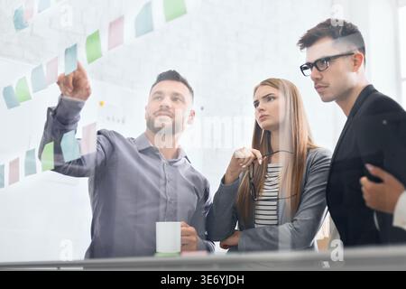 Business investors discussing work looking at notes Stock Photo