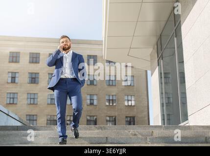 Businessman talking on mobile phone on walk Stock Photo