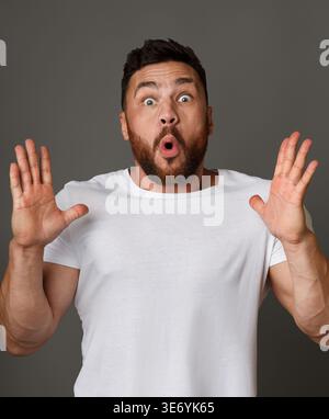 Emotional surprised bearded man standing with open mouth Stock Photo