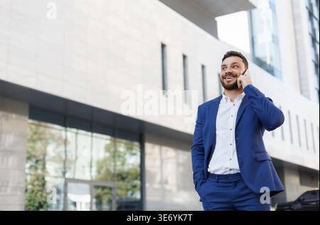 Bearded businessman talking on cell phone with customer Stock Photo