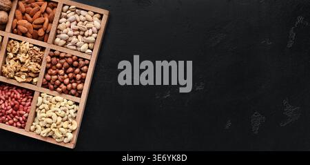 Assortment of nuts in wooden box on black background Stock Photo