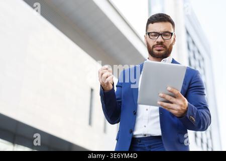 Serious architect in suit with digital tablet outdoor Stock Photo
