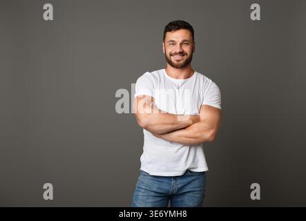 Muscular young man standing with his arms crossed Stock Photo