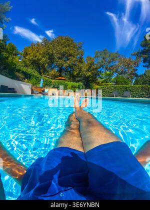 Man relaxing in swimming pool on summer vacation Stock Photo