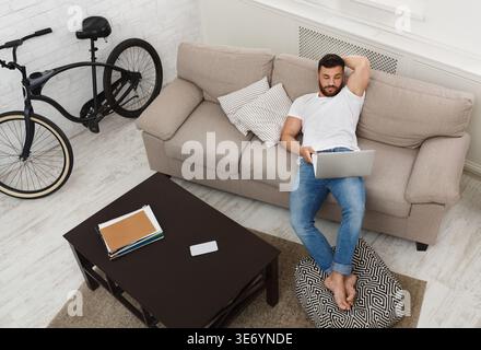 Handsome man working on laptop at home Stock Photo