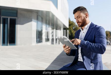 Businessman using digital tablet near office outdoor Stock Photo