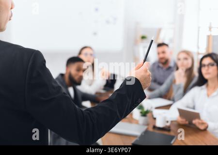 Boss explaining financial plan to colleagues at meeting Stock Photo