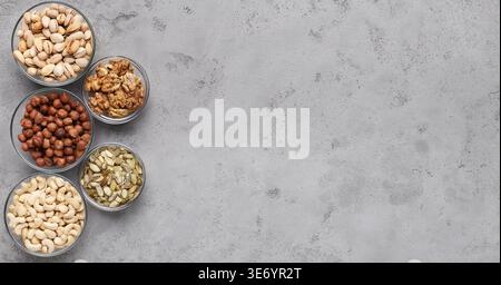 Diet nuts in glass bowls on gray table Stock Photo