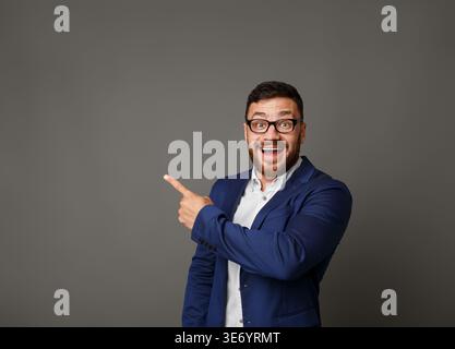 Excited businessman pointing up at copy space Stock Photo