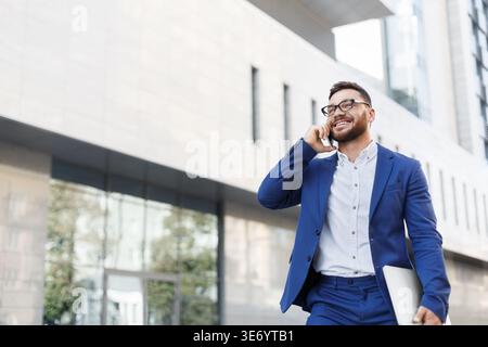 Bearded businessman talking on cell phone with customer Stock Photo