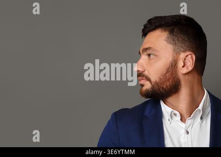 Thinking stylish young bearded businessman looking away Stock Photo