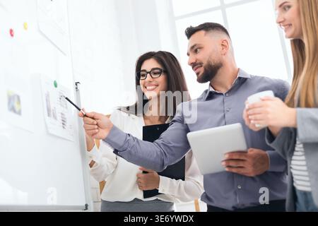 Discussing project together. Confident man showing graphics Stock Photo