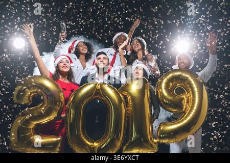 Group of joyful colleagues having fun at new year celebration Stock Photo