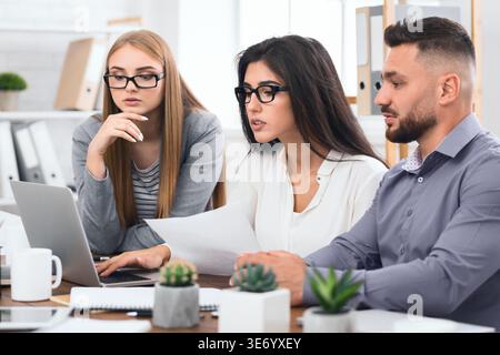 Concentrated business team with laptop and documents Stock Photo