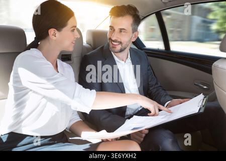 Business partners working with documents in car Stock Photo