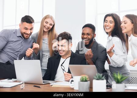 Happy multinational young managers completed hard project Stock Photo