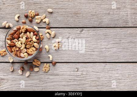 Bowl with mixed nuts on wooden table Stock Photo