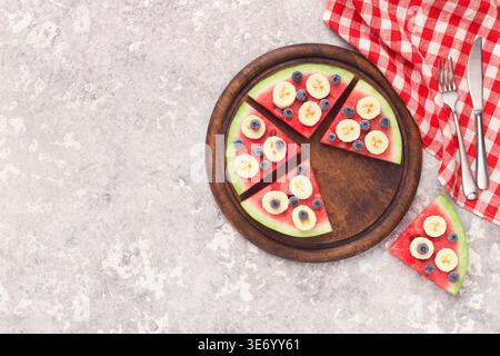 Sliced juicy watermelon pizza with blueberries and bananas Stock Photo