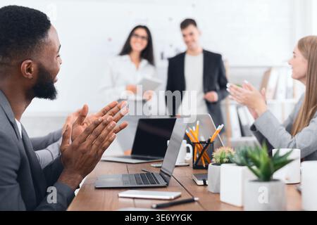 Business seminar. Colleagues clapping hands to speakers Stock Photo