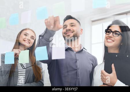 Businessman presenting ideas on sticky notes on glass wall Stock Photo