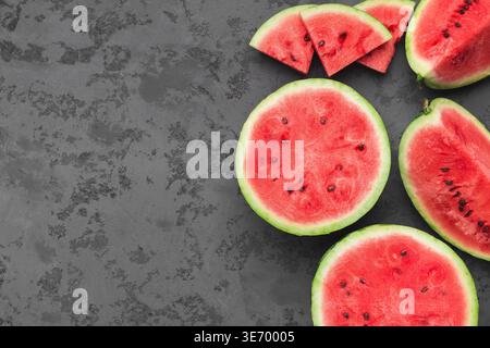 Cut fresh juicy watermelon on dark grey table Stock Photo