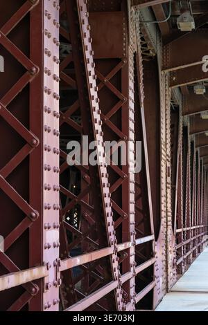 Industrial bridge structure showcasing metal trusses, girders, and riveted beams Stock Photo