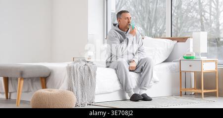 Mature man using nebulizer in bedroom Stock Photo