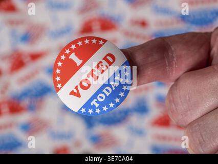 Finger with I Voted Today button in front of many voting stickers given to US voters in Presidential election to illustrate vote rights Stock Photo