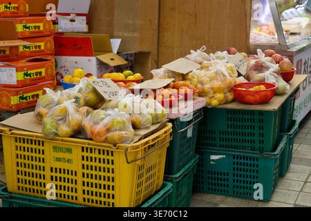 Bagged fruit and citrus sit on stacked plastic crates beside a stall inside Eonyang Alps Market, adding a simple produce display to the arcade. Stock Photo