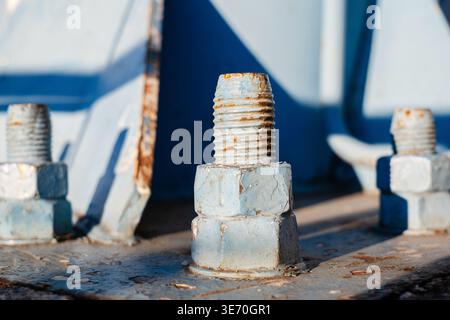 Macro shot of weathered blue painted steel bolts with visible rust and texture Stock Photo