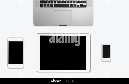 Modern computing equipment of smartphone, tablet, music player and laptop arranged on simple white desktop with copy space Stock Photo