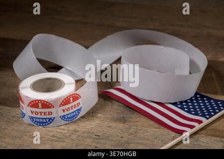 Large roll of I Voted Today stickers with many having been used for voters in the US elections with USA flag on table Stock Photo