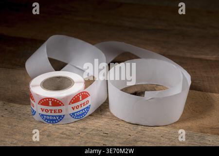 Large roll of I Voted Today stickers with many having been used for voters in the US elections on rustic rural wooden table Stock Photo