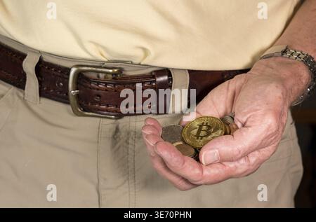 Concept of bitcoin or cyber currency only worth as much as loose change in mans hand Stock Photo