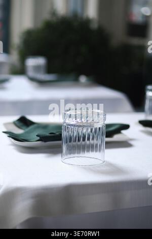 Clear glass on white tablecloth in restaurant Stock Photo