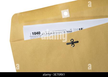 Printed copy of Form 1040 for income tax return in a plain brown envelope with copy space Stock Photo