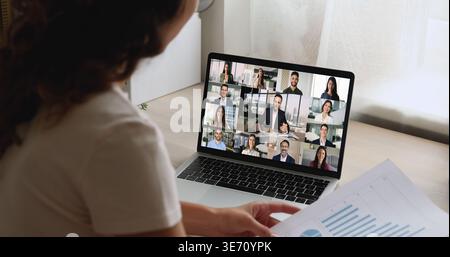 Businesswoman engages in videocall with group displayed on laptop screen Stock Photo