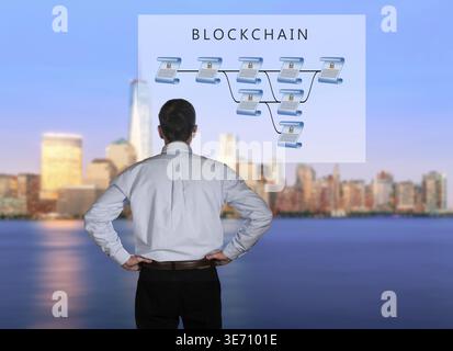 Blockchain schematic on glass panel with senior technology executive looking at the chart with New York city in background Stock Photo