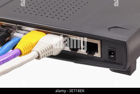 Macro shot of plugs on cat5e cables of many colors isolated against white background plugged into router Stock Photo