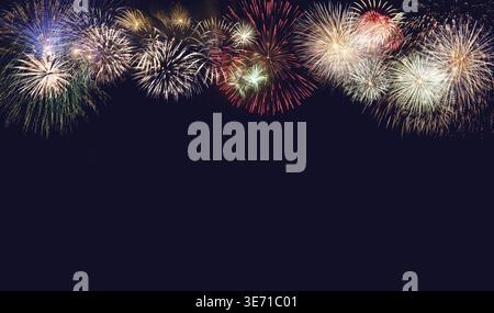 Composite of multiple firework explosions against dark blue sky with copy space for New Years or Independence day celebrations Stock Photo