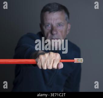 Senior engineer restricting flow of traffic in the internet to illustrate hacking or net neutrality Stock Photo