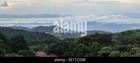 View west from Monteverde resort at sunrise over the hills towards Pacific ocean in broad panoramic format Stock Photo