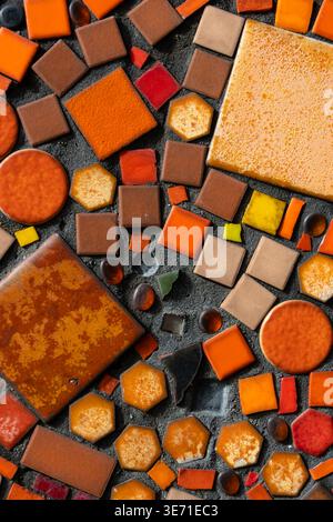 Colorful mosaic random pattern on dark cement mortar, featuring ceramic tiles and glass pieces Stock Photo