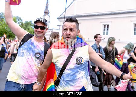 Klagenfurt, Austria - August 03, 2024: Two men in colorful shirts are joyfully participating in pride parade, showcasing love and acceptance in urban Stock Photo
