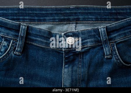 Blue jeans isolated on dark background representing casual fashion style Stock Photo