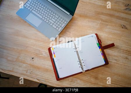 Workspace with laptop and personal organizer reflecting planning and achieving goals Stock Photo