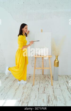 A Joyful Artist Proudly Showcasing Their Colorful Paint Brushes in a Bright and Inspiring Studio Environment Stock Photo