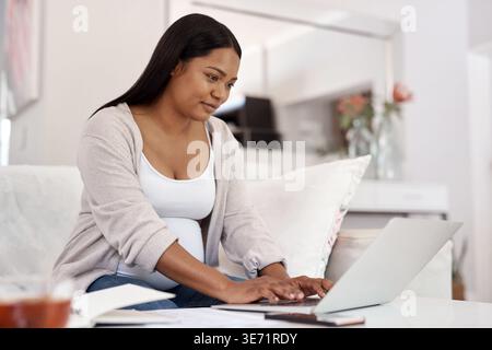 Reading, typing or pregnant woman with laptop on couch, maternity forum or research on fetus development. Home, learn or person with pc for childbirth Stock Photo