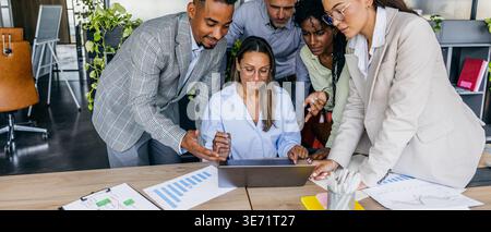 Business professionals focus on graphs and financial documents together Stock Photo
