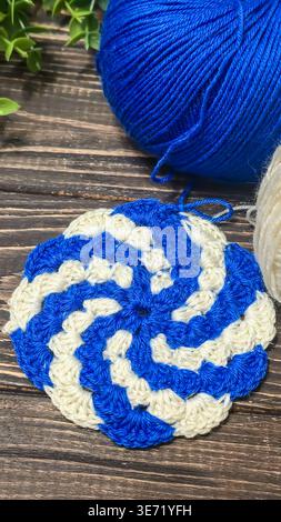 A raised openwork pattern knitted with colored yarn on a wooden background. Knitting tutorial. Fabric texture. Stock Photo